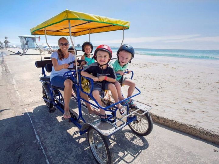 Surrey bike rentals on the Northshore — family riding a four-wheel surrey together in Mandeville